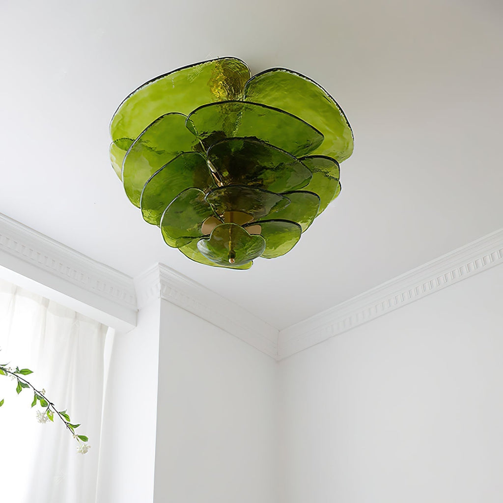 Green Clérachic lotus leaf chandelier unlit on a white ceiling, dark-rimmed leaves fanning over the cornice.