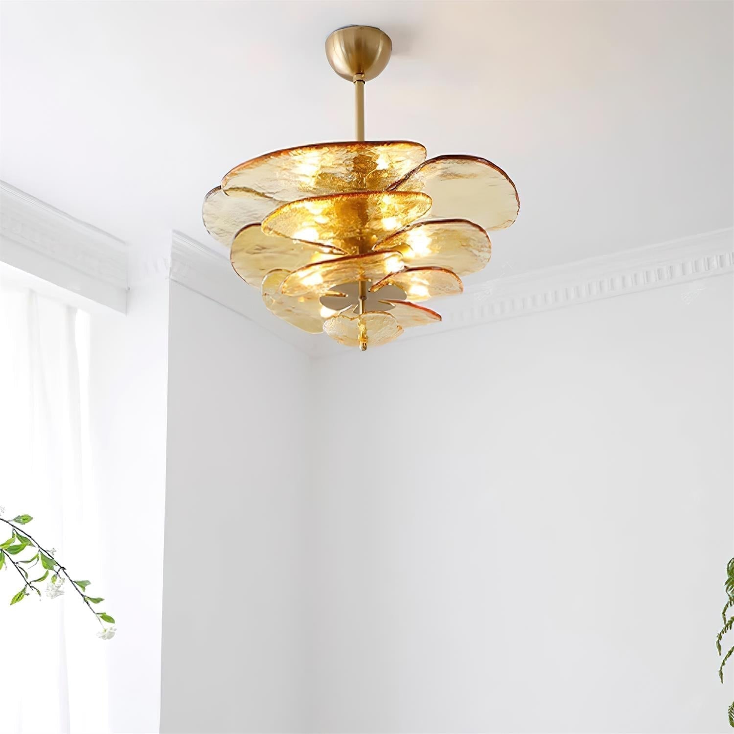 Amber Clérachic lotus leaf chandelier lit in a corner with cornice moulding and daylight from a nearby window.