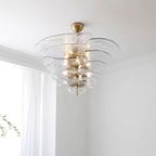 Clear Clérachic lotus leaf chandelier lit in a bright corner, light bouncing off the stacked transparent leaves.