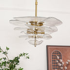 Unlit clear Clérachic lotus leaf chandelier on its brass rod, the E14 sockets visible between the glass tiers.
