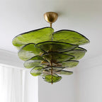 Green Clérachic Lotus Leaf Glass Chandelier fitted close to the ceiling, seen from below beside a white curtain.