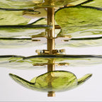 Close-up of the Clérachic chandelier's brass column, disc mounts and capsule bulbs between the green glass leaves.