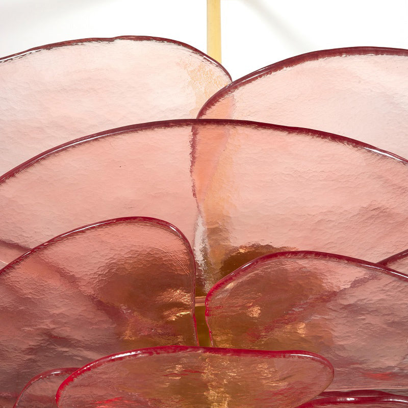 Close-up of the pink glass leaves on the Clérachic lotus leaf chandelier, each rimmed in deep red around the rod.