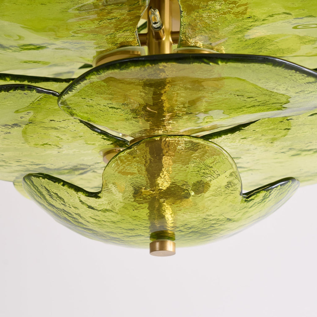 Underside close-up of the Clérachic chandelier's lowest green glass bowl and the brass finial beneath it.