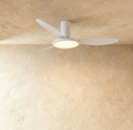 Clérachic matte white ceiling fan with a light: three slim blades and a round LED disc glowing warm under the motor, in studio.