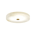 Clérachic low-profile drum flush mount ceiling light in white alabaster with a brushed brass centre cap, shown unlit on white.
