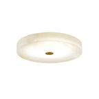 Clérachic low-profile drum flush mount ceiling light in white alabaster with a brushed brass centre cap, shown unlit on white.