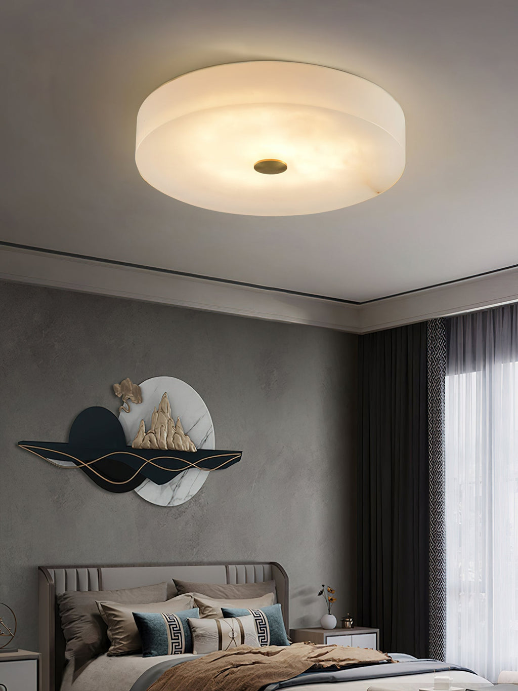 A Clérachic flush mount ceiling light lighting a bedroom from a low ceiling, its alabaster drum reading as one soft lit surface.