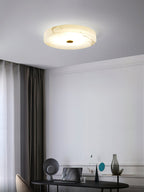 Clérachic drum ceiling light over a study corner, warm light spreading across the veined alabaster above a desk and laptop.