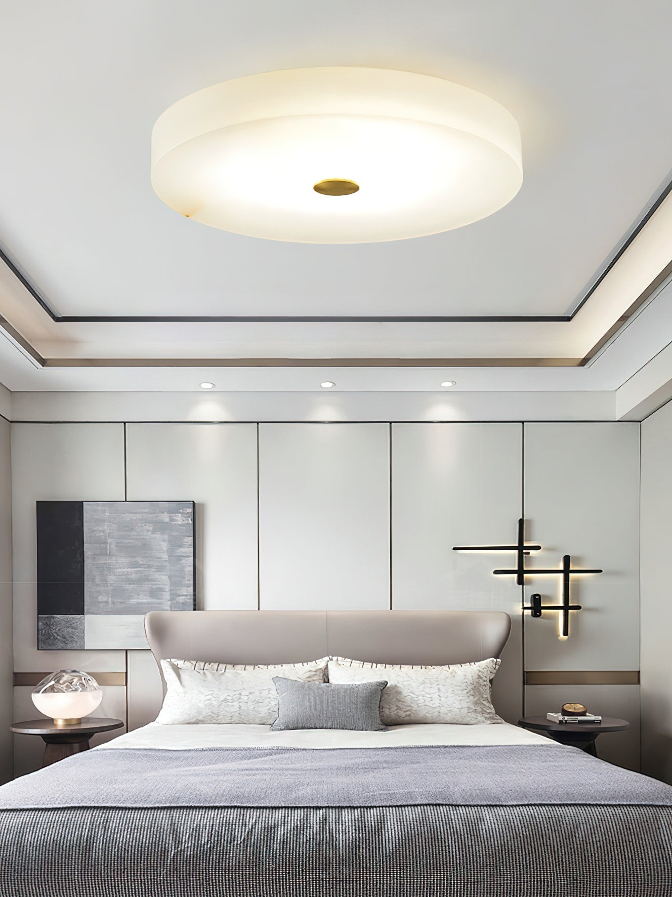 Clérachic flush mount ceiling light centred on a tray ceiling above an upholstered bed, casting an even wash over the room.