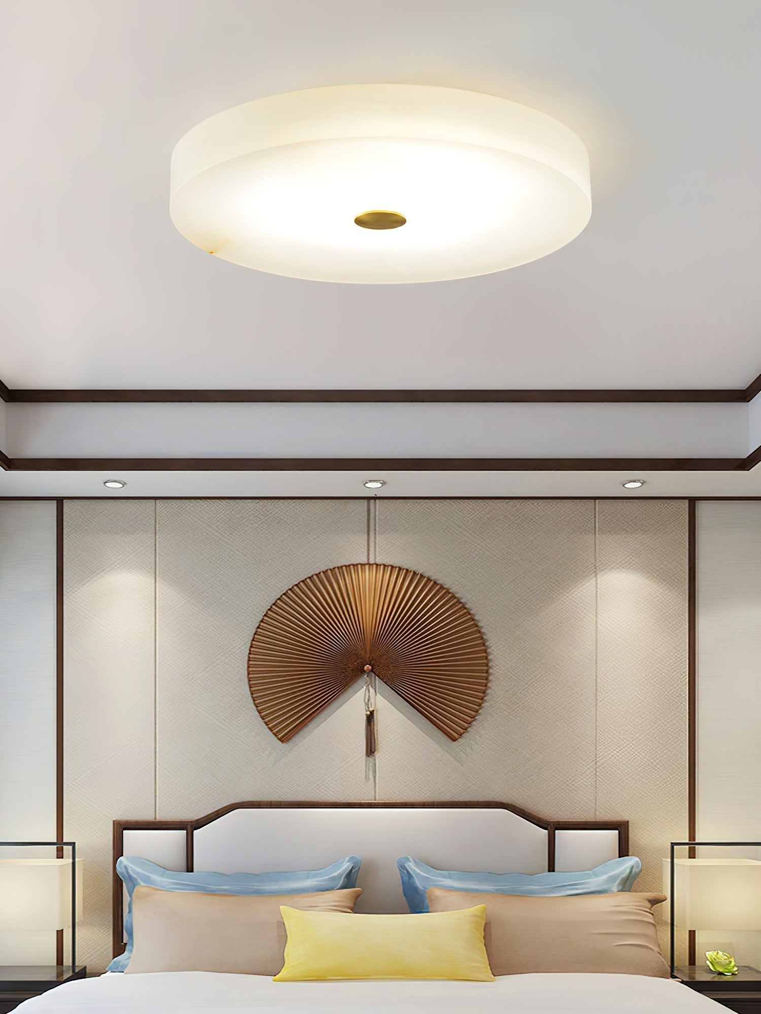 Straight-on view of the Clérachic drum flush mount ceiling light, its brass cap centred on a broad disc of glowing alabaster.
