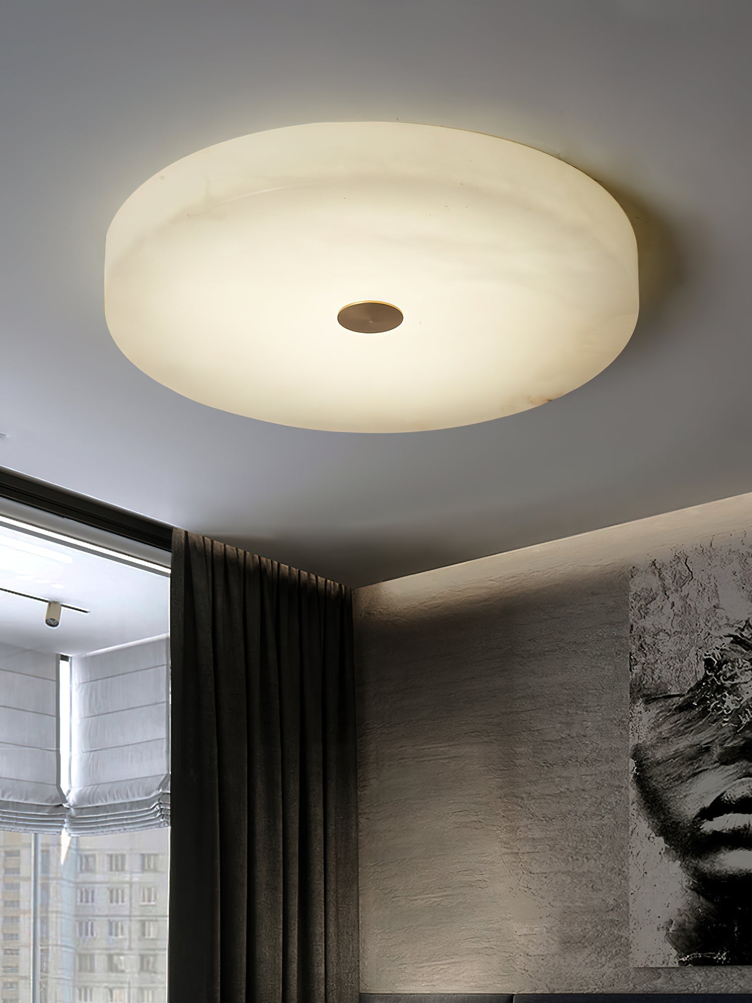 Clérachic flush mount ceiling light seen wide against a plain ceiling, pale alabaster edge to edge with a small brass centre.