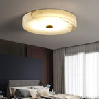 Angled view of the Clérachic flush mount ceiling light, tan veining running across the alabaster as the LED lights it from within.