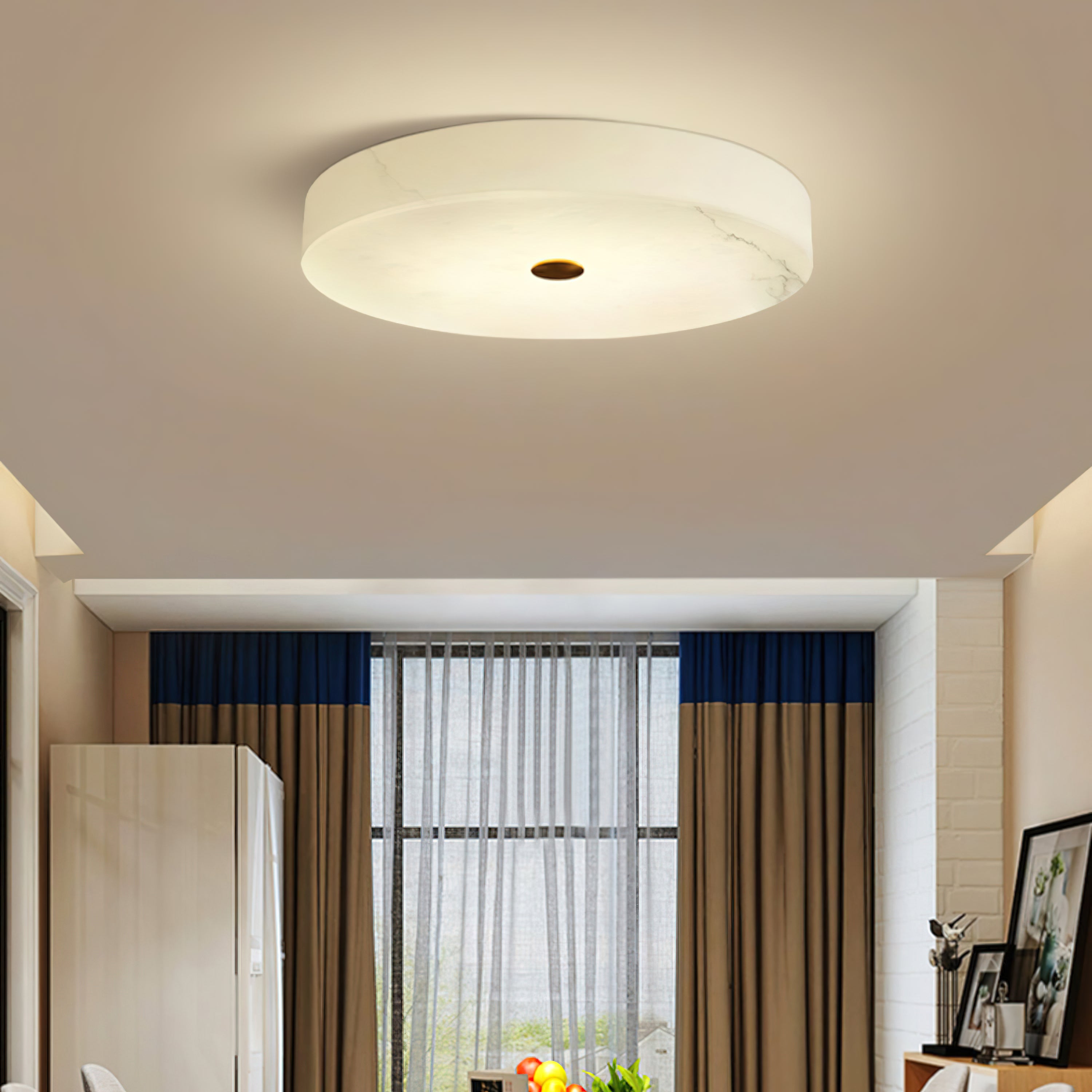 Clérachic drum ceiling light over a bright dining corner, the veined alabaster spreading an even glow with no bulb in view.