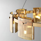 Close view of curved amber glass panels on the gold band of this Clérachic chandelier, with a small bulb visible inside.