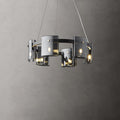 Lit black-frame chandelier from Clérachic with a smaller ring of smoked glass shades, against a dark grey wall.