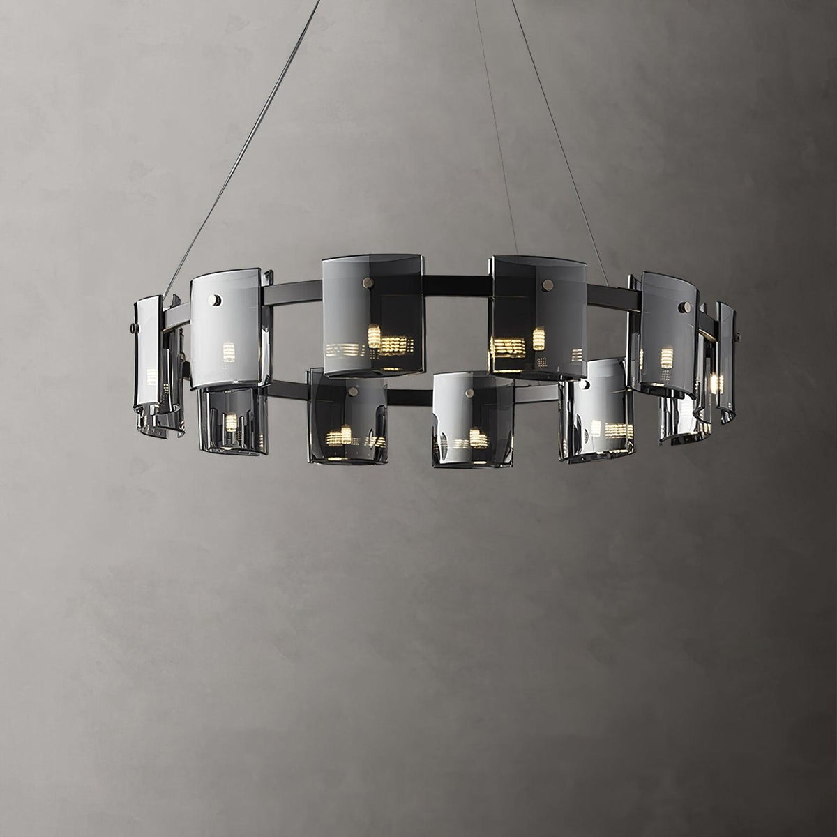Black-frame ring chandelier from Clérachic with a double row of smoked glass shades, shown against a textured grey wall.