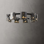 Wide black ring chandelier from Clérachic with smoked glass shades hung in staggered heights on thin cables against a grey wall.