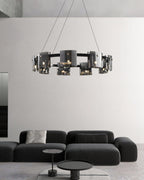 Black ring chandelier from Clérachic with smoked glass shades above a low black sofa and two small round side tables.