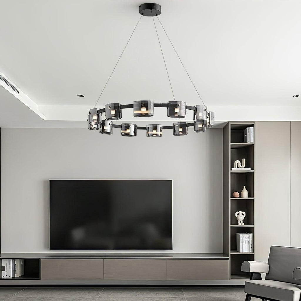 Black ring chandelier from Clérachic hung in a living room with a wall television, built-in shelves and a recessed ceiling.