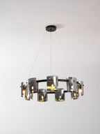 Black-frame chandelier from Clérachic with smoked glass shades and a round black canopy, lit, against a light backdrop.