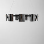 Side-on close view of the black band and smoked glass shades of this Clérachic chandelier against a pale grey wall.