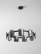 Black ring chandelier from Clérachic with smoked glass shades staggered around the band, below a round black canopy.