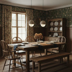 Clérachic Lunar pendants above a farmhouse dining table in a green-papered room.
