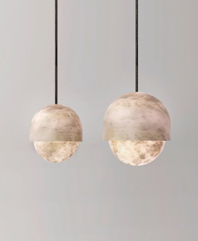 A pair of Clérachic Lunar pendants at different heights on grey, both lit warm.