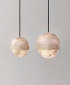 A pair of Clérachic Lunar pendants at different heights on grey, both lit warm.