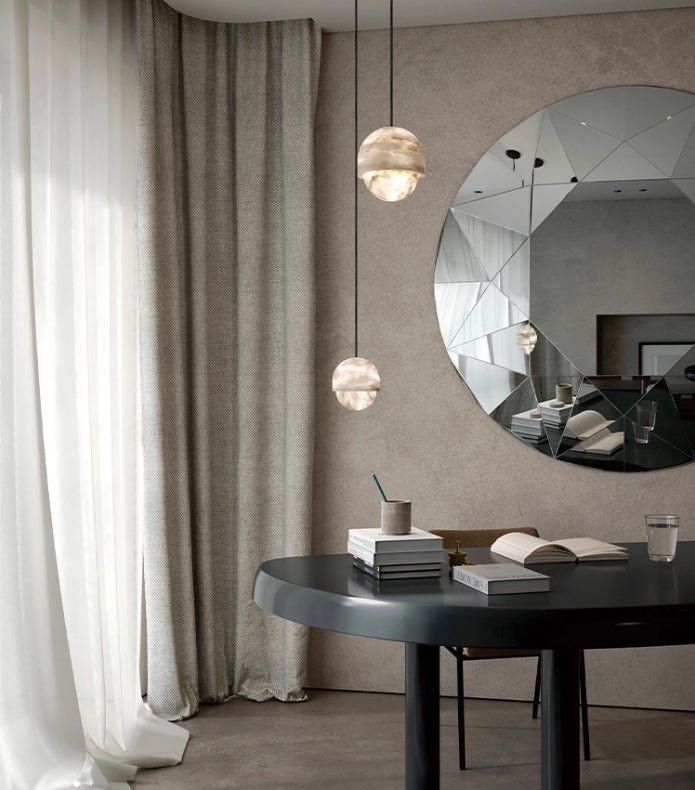 Clérachic Lunar pendants over a desk by a round mirror and floor-length curtains.
