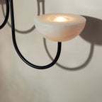 Close view of one Clérachic Lunaris bowl in black finish, bulb glowing in the stone dish.