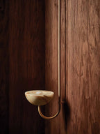 Clérachic Lunaris single-arm light in brass mounted against dark walnut panelling.