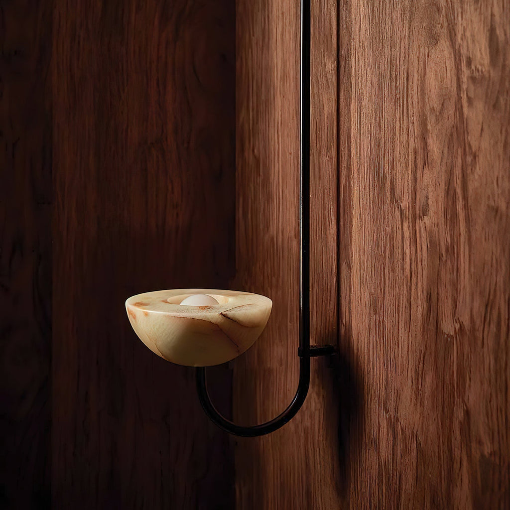 The Clérachic Lunaris single-arm light in black against a walnut wall, bowl lit warm.