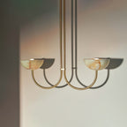 Clérachic Lunaris pendant in brass with two alabaster bowls lit above a pale wall.