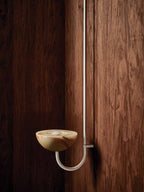 Clérachic Lunaris single light in white against dark timber, curved arm sweeping down.