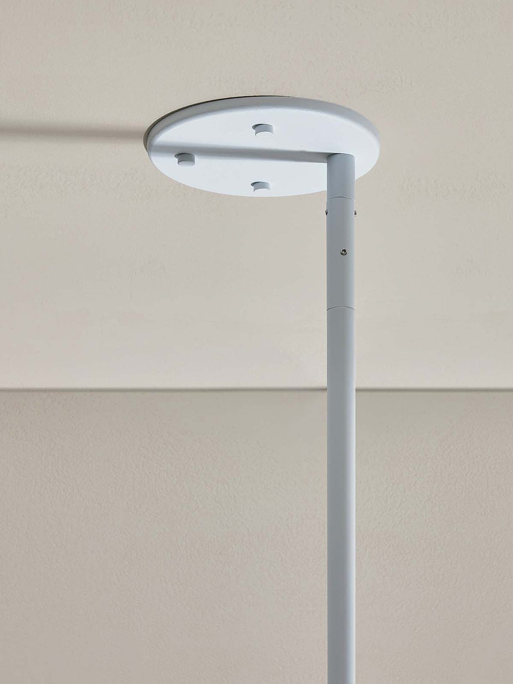 Detail of the Clérachic Lunaris ceiling plate in white, stem fixed to the flat canopy.