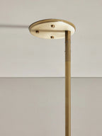 Detail of the Clérachic Lunaris ceiling plate in brass against a pale ceiling.
