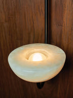 Macro of the Clérachic Lunaris bowl on black, pale green-white alabaster lit from inside.