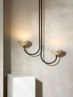 Clérachic Lunaris pendant in black, both alabaster bowls lit above a white plinth.