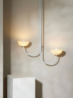 The Clérachic Lunaris pendant in white finish, arms and stem picked out against plaster.