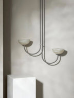 Clérachic Lunaris pendant in nickel, twin stone bowls throwing light up the wall.