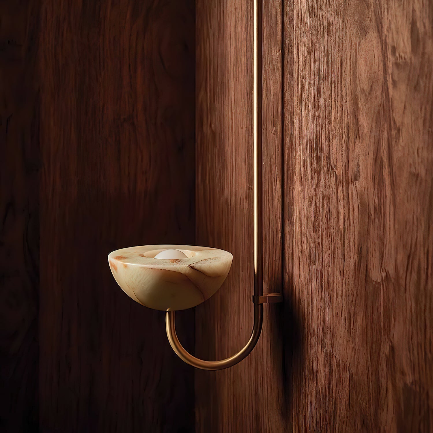 Clérachic Lunaris single light in brass on walnut, warm bowl glowing at eye level.