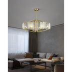 The Clérachic chandelier in a bright living room, brass arms and pale alabaster set off by sheer curtains.