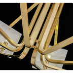 Close view of the Clérachic chandelier's brushed brass arms crossing at the hub beside an alabaster edge.
