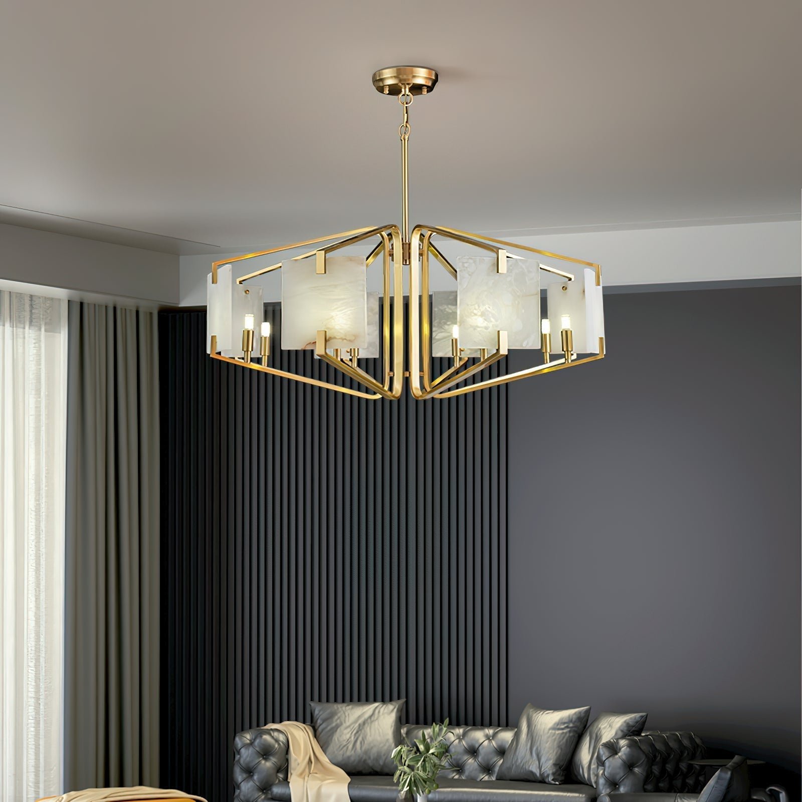 The Clérachic chandelier lit above a buttoned sofa, framed by black ribbed drapery running behind it.