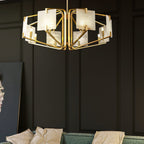 The Clérachic chandelier glowing on a dark panelled wall, brass frame above a green velvet corner sofa.
