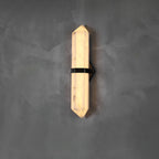 The Clérachic Lustra square to the wall, faceted stone lit evenly from the pyramid tip downward.