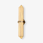 The Clérachic Lustra shown small on white, a compact faceted sconce with warm brass hardware at its waist.