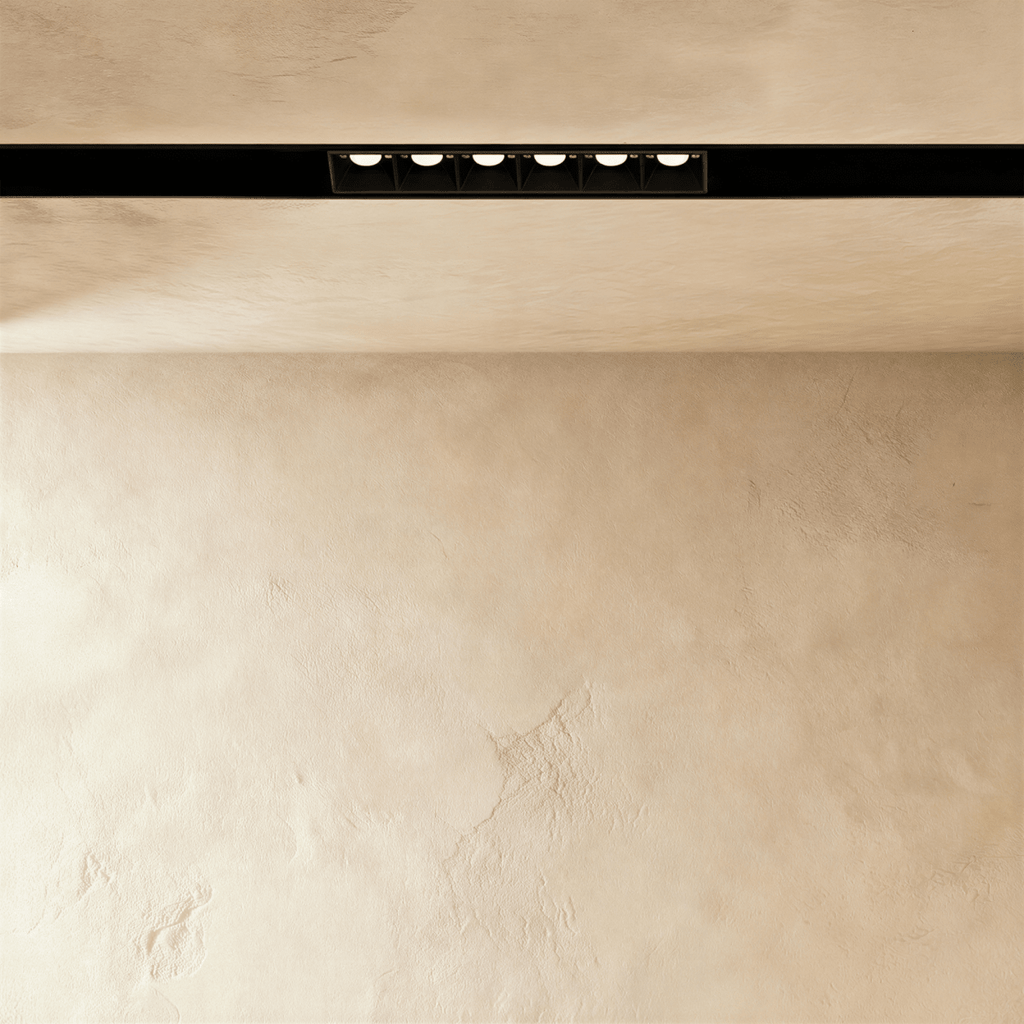 Clérachic recessed grille head lit from below, the six lenses reading as separate points of light.